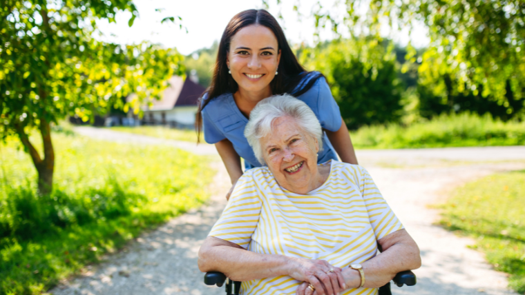 Professional NEMT driver assisting elderly patient in wheelchair during hospital discharge