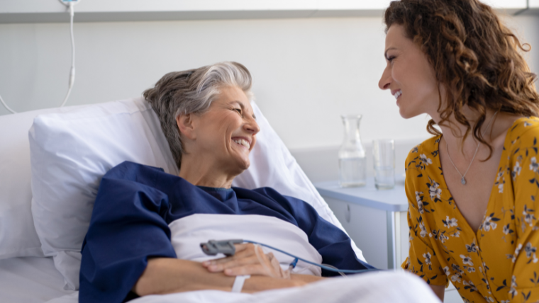 Adult daughter helping elderly mother with mobility support in a South Florida home
